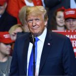 Andy Ogles Proposes Constitutional Amendment to Expand Presidential Term Limits to Three Terms Person at a rally with Make America Great Again signs.