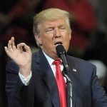 Fani Willis Appeals Removal from Georgia Election Interference Case Involving Donald Trump Man in suit speaking at a microphone.