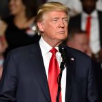 Trump’s Pardons for January 6 Capitol Breach: A Focus on Non-Violent Offenders Man in suit speaking at an event.