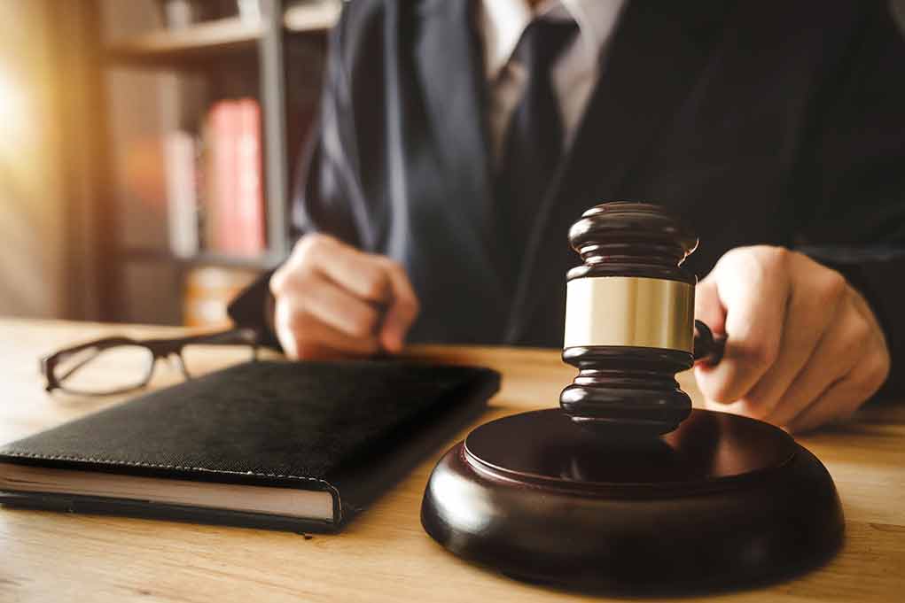 1035925210 featured image Judge holding gavel at desk.
