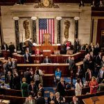 Crowded legislative chamber with people in discussion
