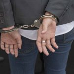 Hands in handcuffs behind back.
