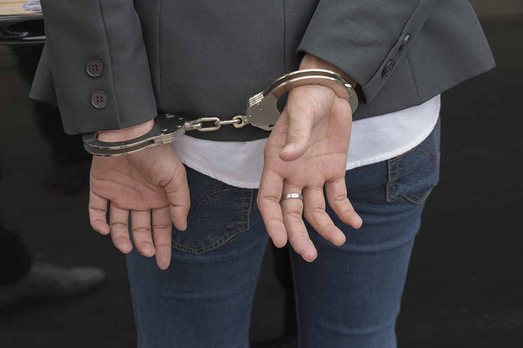 568580932 featured image Hands in handcuffs behind back.