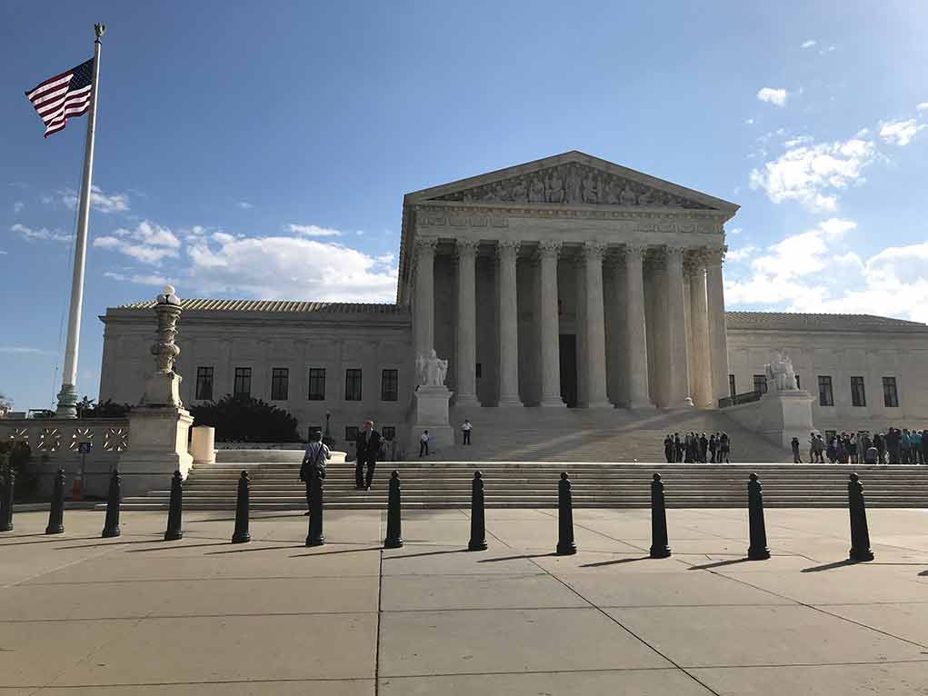 2453289175 featured image Supreme Court building with flag and people outside.