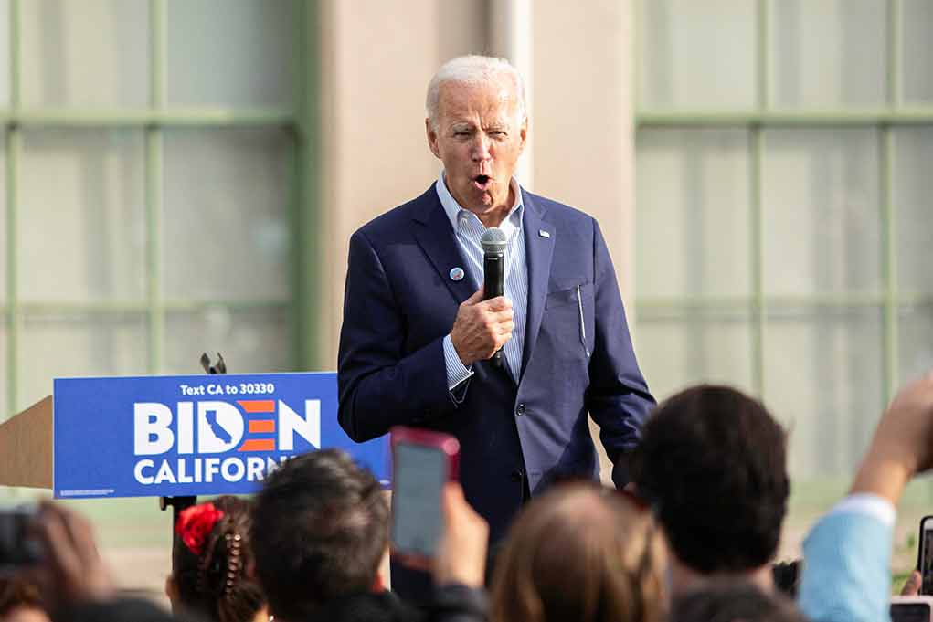 1638697603 featured image Man speaking at an outdoor event with Biden sign