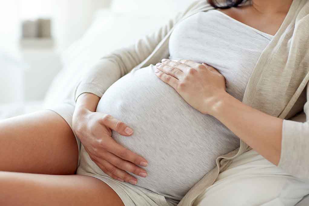 564114571 featured image Pregnant woman holding her belly sitting comfortably