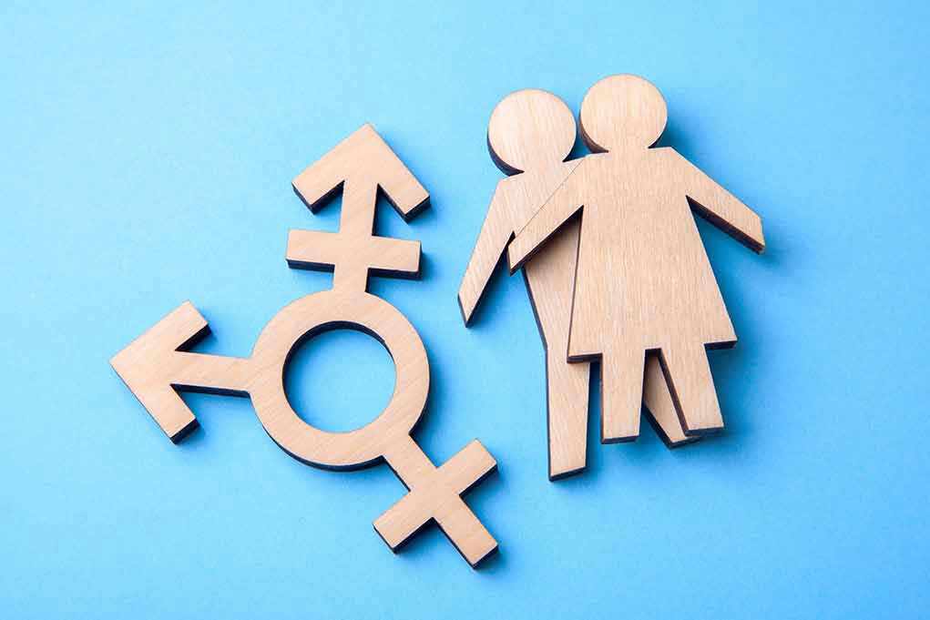 1145016626 Wooden transgender symbol and couple figures on blue background