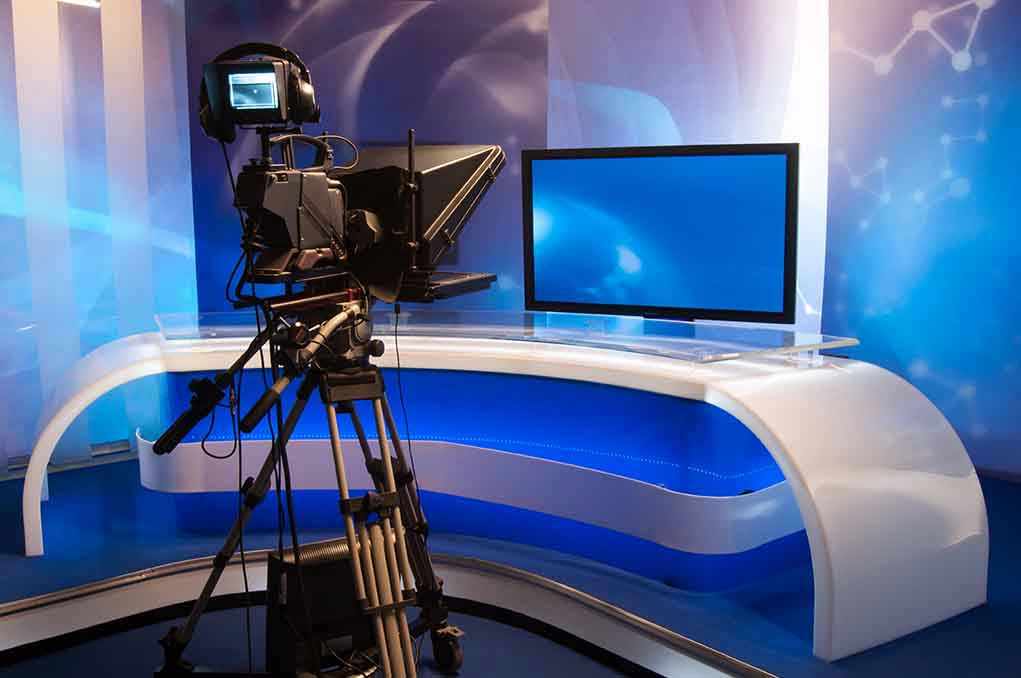 TV studio with camera and empty anchor desk