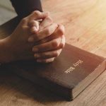 Chaplains WELCOME—Critics EXPLODE Over Move Hands praying on a Bible