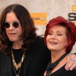 Ozzy Death Sparks Sharon Firestorm A celebrity couple posing together at a red carpet event smiling and dressed in stylish outfits