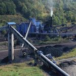 Community in Fear: Aftermath of Steel Plant Explosion Industrial coal processing plant with conveyor belts and smokestack.