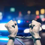 Bartenders Busted—116 Underage Sales Exposed Hands in handcuffs in front of police cars.