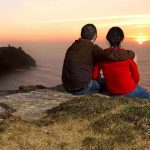 Husband Murders Wife, Blames ICE?? A couple sitting on a cliff watching the sunset over the ocean