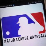 Outrage as SPORTS IGNORES Murder – Radio Silence! Major League Baseball logo on a smartphone screen.