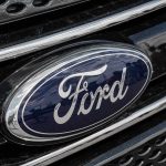 Ford Tech Mandate Backfires—1.9 Million Cars RECALLED Ford logo on car grille close-up.