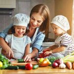 Family cooking together with vegetables in kitchen