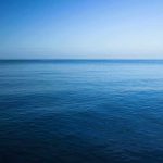 A calm ocean under a clear blue sky