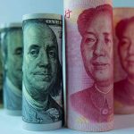 Rolled US dollar and Chinese yuan banknotes.