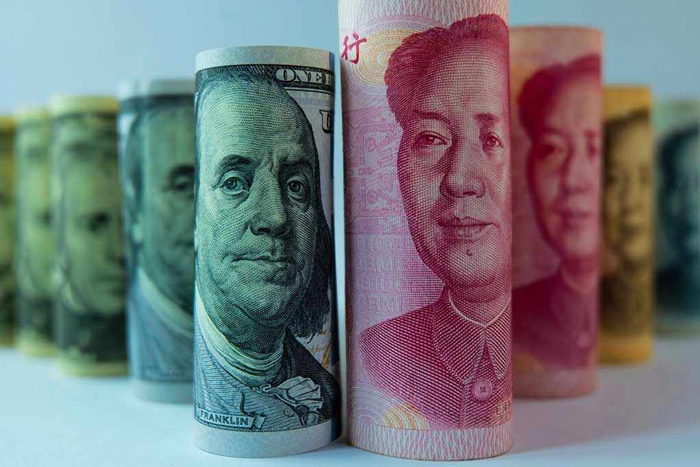 Rolled US dollar and Chinese yuan banknotes.