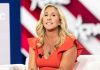 GOP ABANDON Own Nominee For Dem – MTG Explodes! Woman speaking at an event, wearing a red dress.