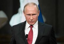 Putin’s Tsunami Weapon STUNS Pentagon – Wow! Person speaking into a microphone, official setting.
