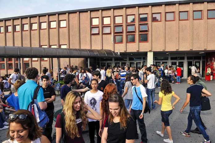 shutterstock_181110272.jpg A large group of students socializing outside a school building