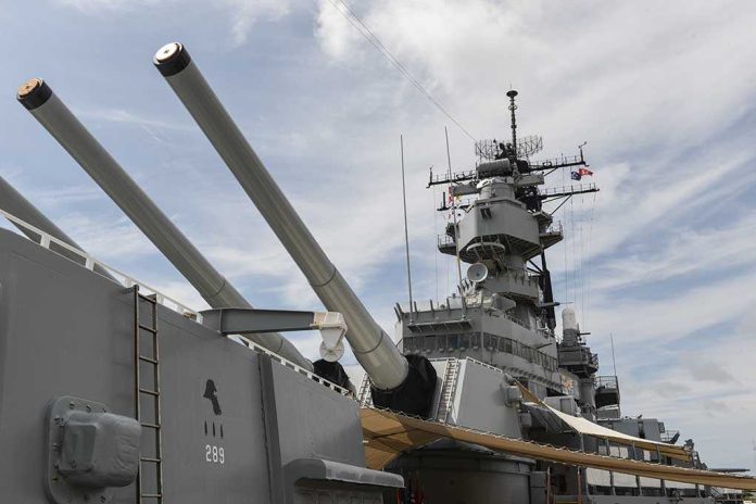 shutterstock_224332015.jpg Close-up of a battleships naval guns and superstructure against a cloudy sky