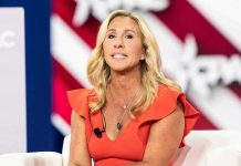 Woman speaking at an event, wearing a red dress.