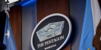 The Pentagon emblem between two flags.