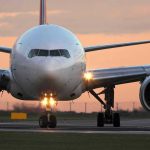 Half World’s Planes GROUNDED – Travel CHAOS! Airplane on runway during sunset.