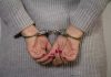 Top Judge ARRESTED – Shocking Scandal Unfolds Person in handcuffs with gray sweater.
