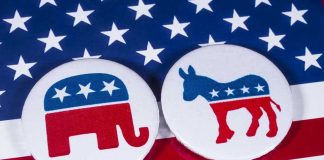 Republican elephant and Democrat donkey on American flag.
