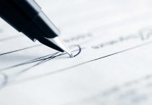 Scandal Erupts – Trump’s SUSPICIOUS Pardon Signatures Close-up of a pen poised above a document with handwritten lines