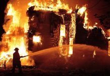 NBA Coaches Home ERUPTS—Total Destruction A firefighter battling a large house fire at night