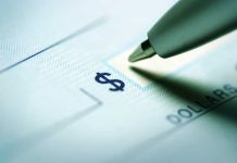 Close-up of a pen poised over a check with a dollar sign