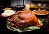 A beautifully roasted turkey on a festive table surrounded by side dishes and decorations