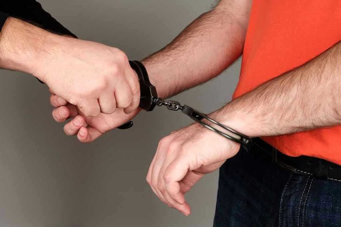 1340097212 Person handcuffing another persons wrists
