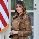 Putin HUMILIATES Trump – Melania Steps In Woman in brown coat beside American flag.