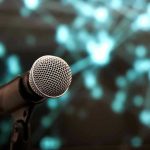 Microphone with abstract, blurred blue background.