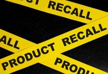Yellow tape with product recall text on black background.