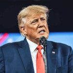 House Majority CRUMBLES – Trump Scrambles With Endorsement Man in suit speaking at a microphone.