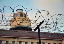 Gourmet Drone Drop Stuns Prison Guards Barbed wire in front of a prison tower.