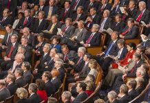 House Leaders CANCEL Vote – Crucial Bill Dies Mysteriously Audience of officials sitting and reading documents in auditorium.