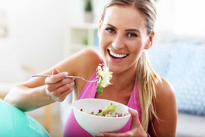Woman smiling and eating a salad bowl.