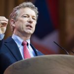 Man in a suit delivering a speech at a podium