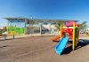 Colorful playground slide in front of a building.