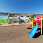 Colorful playground slide in front of a building.