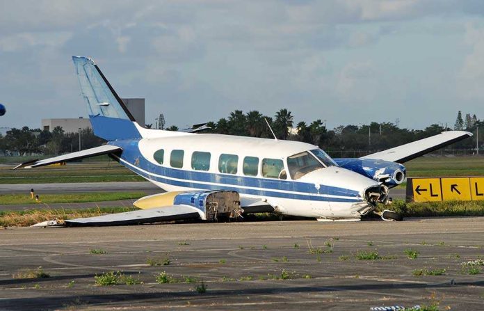 Damaged blue and white small airplane on an airport runway
