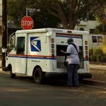 SCOTUS Rules 5-4, USPS Survives NARROW Vote! USPS mail carrier at truck near stop sign.