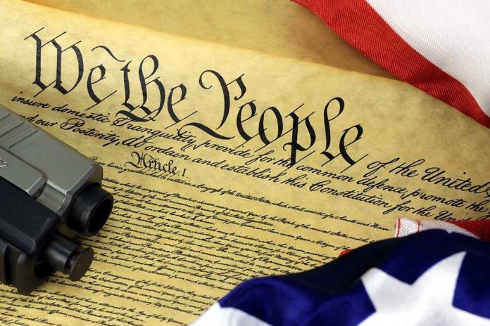 Close-up of the U.S. Constitution with a firearm and American flag